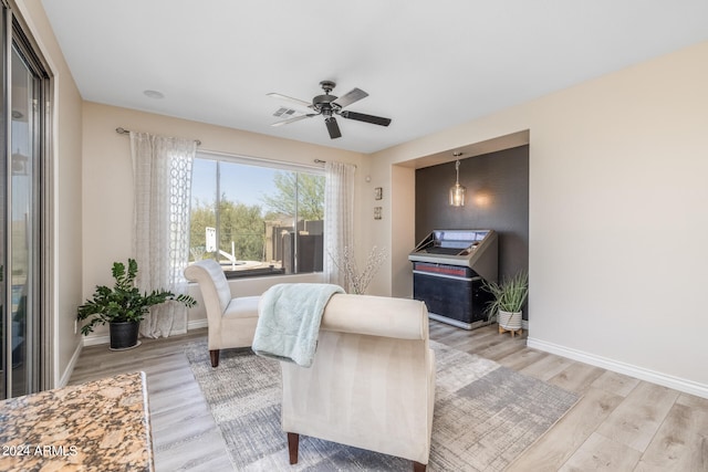 living area with ceiling fan and light hardwood / wood-style floors