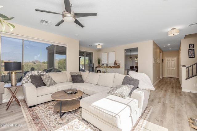 living room featuring ceiling fan and light hardwood / wood-style floors