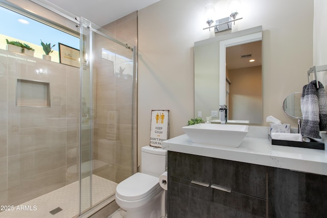 bathroom with visible vents, a stall shower, toilet, and vanity