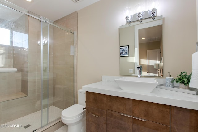 bathroom with vanity, toilet, and a stall shower