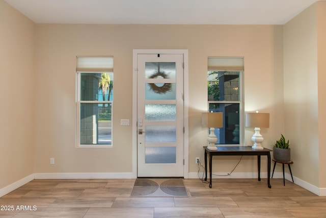 doorway with baseboards and wood finished floors