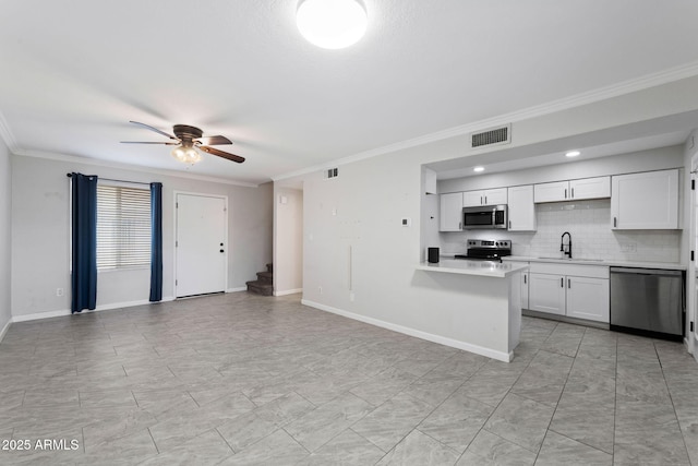 kitchen with open floor plan, light countertops, appliances with stainless steel finishes, and white cabinets