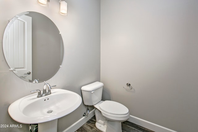 bathroom featuring toilet, hardwood / wood-style floors, and sink