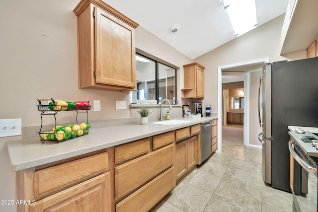 kitchen featuring appliances with stainless steel finishes, light brown cabinets, light tile patterned flooring, lofted ceiling, and sink