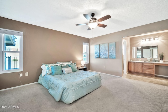 carpeted bedroom featuring ceiling fan, connected bathroom, and a textured ceiling