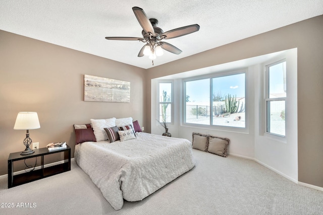 bedroom with ceiling fan, a textured ceiling, and carpet flooring