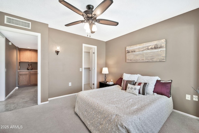 carpeted bedroom featuring ceiling fan, a walk in closet, and a closet