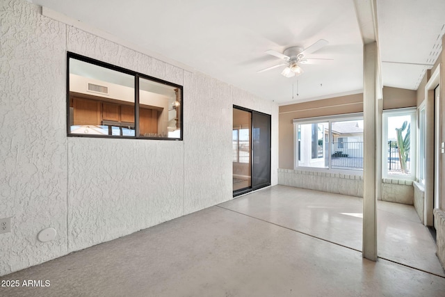 interior space featuring ceiling fan and concrete flooring