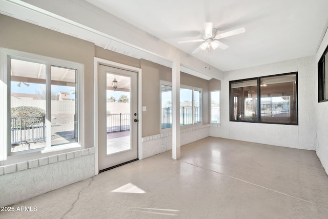 unfurnished sunroom with ceiling fan