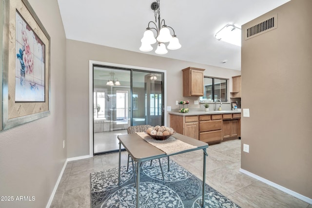 dining area featuring light tile patterned floors, sink, and an inviting chandelier