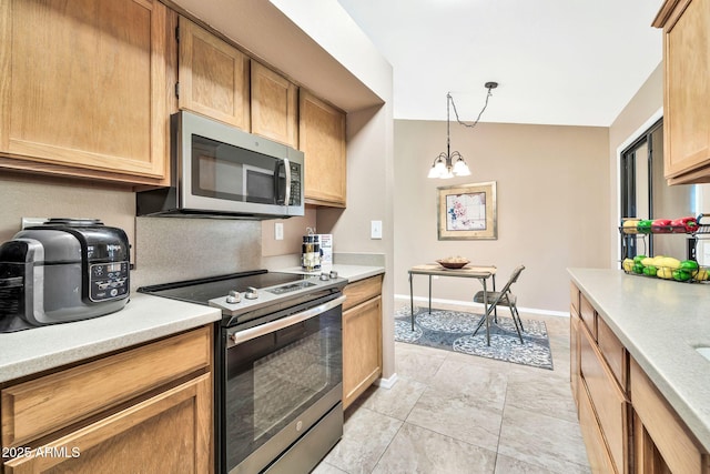 kitchen featuring hanging light fixtures, appliances with stainless steel finishes, light tile patterned flooring, and a chandelier