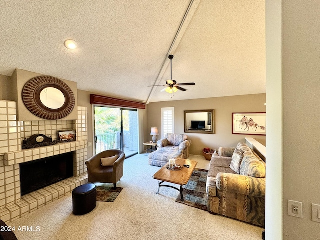 carpeted living room featuring a brick fireplace, a textured ceiling, ceiling fan, and vaulted ceiling