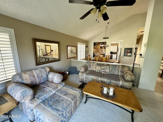 carpeted living room with vaulted ceiling, ceiling fan, and a textured ceiling