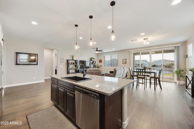 kitchen with stainless steel dishwasher, wood finished floors, a sink, open floor plan, and recessed lighting