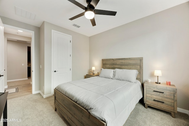 bedroom with visible vents, a ceiling fan, baseboards, and light carpet