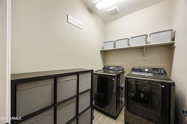 laundry room featuring light wood-type flooring, visible vents, washer and dryer, and laundry area