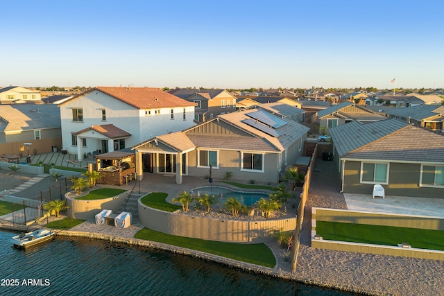 rear view of property featuring a patio area, a fenced backyard, a fenced in pool, and a residential view