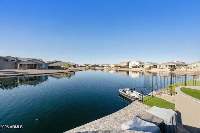 dock area with a residential view, a water view, and fence
