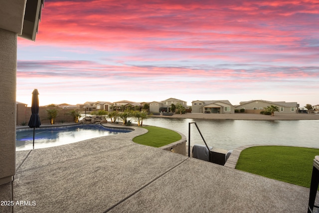 outdoor pool featuring a water view, a residential view, and a patio