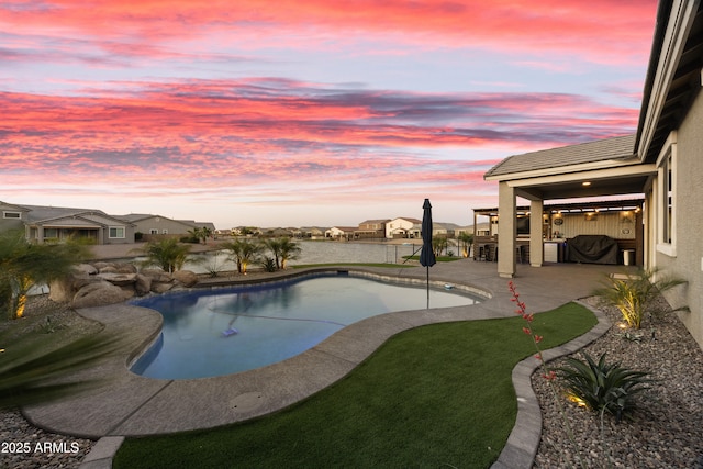 pool at dusk with a fenced in pool and a patio