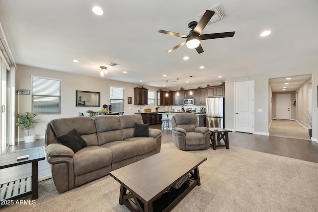 living room featuring plenty of natural light, visible vents, carpet floors, and recessed lighting