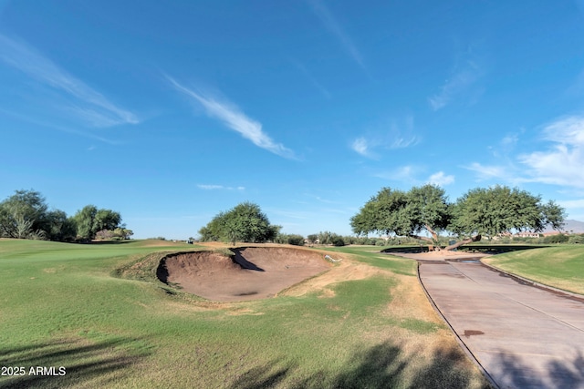 view of property's community with a yard and view of golf course
