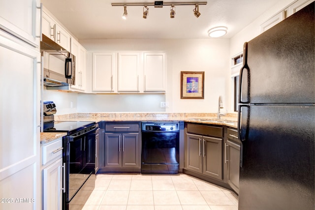 kitchen featuring light stone countertops, light tile patterned floors, black appliances, white cabinets, and sink