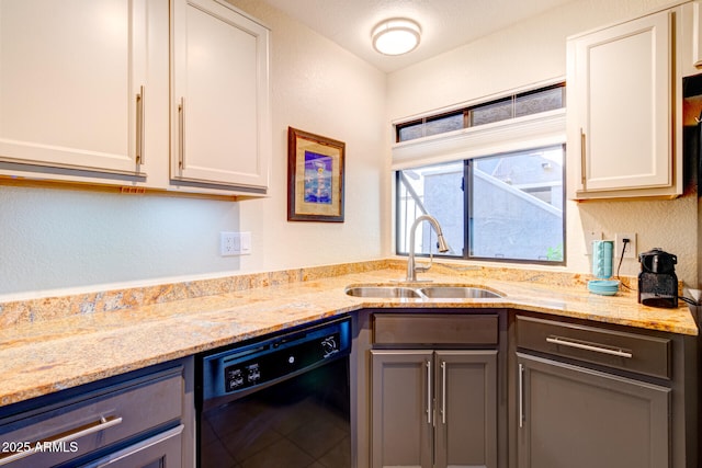 kitchen featuring white cabinets, dishwasher, light stone counters, and sink