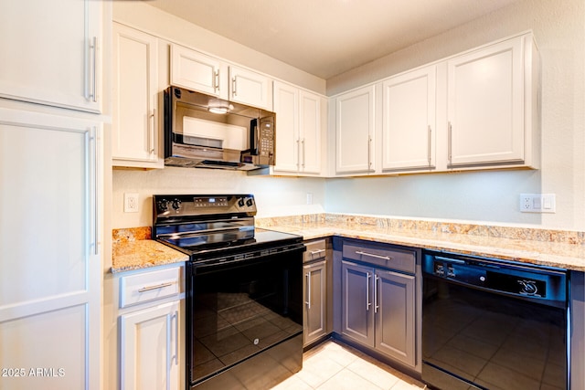 kitchen featuring light stone counters, light tile patterned floors, black appliances, and white cabinetry