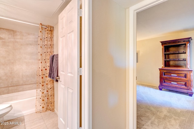 bathroom featuring toilet, tile patterned flooring, and shower / bath combo with shower curtain