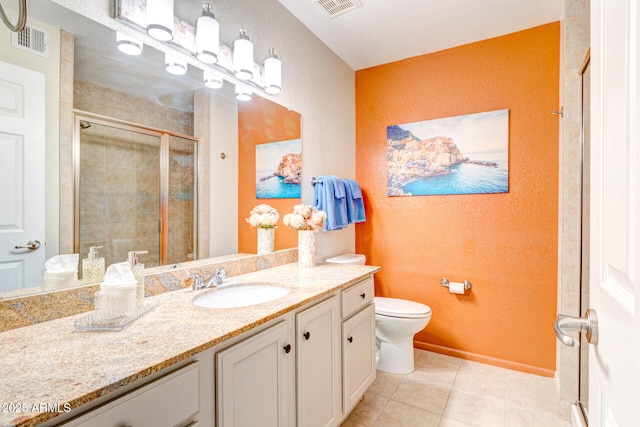 bathroom featuring toilet, tile patterned flooring, vanity, and walk in shower