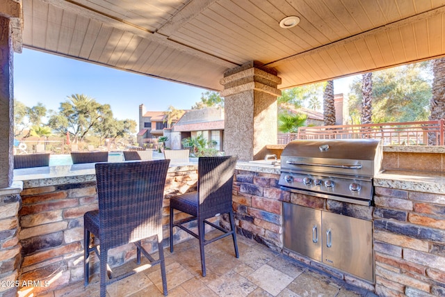 view of patio / terrace with exterior bar, exterior kitchen, and grilling area