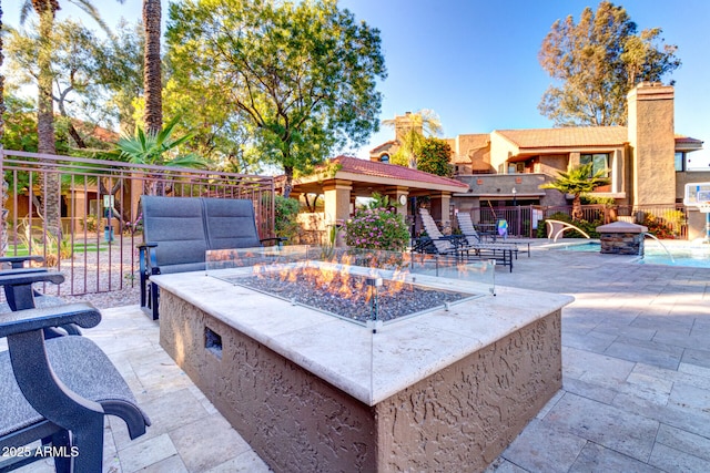 view of patio / terrace featuring pool water feature and an outdoor fire pit