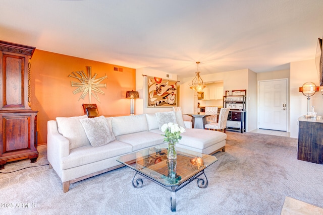 carpeted living room with an inviting chandelier