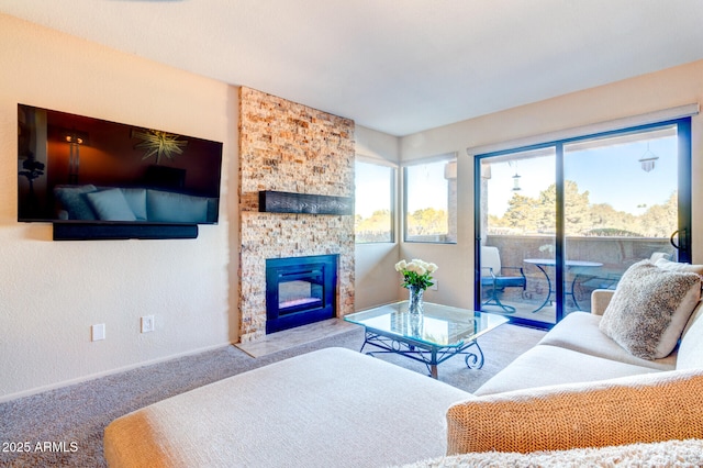 living room featuring light colored carpet and a stone fireplace