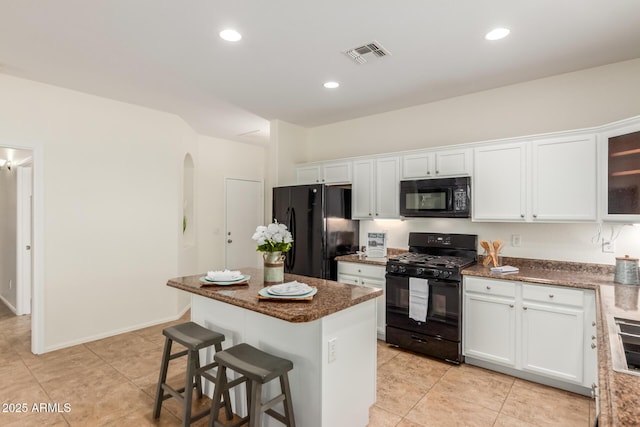 871 E Melanie St, San Tan Valley, AZ 85140 - kitchen featuring black appliances, arched walkways, white cabinetry, a kitchen breakfast bar, and light tile patterned floors