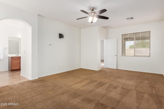 871 E Melanie St, San Tan Valley, AZ 85140 - unfurnished room with arched walkways, light carpet, a ceiling fan, and baseboards