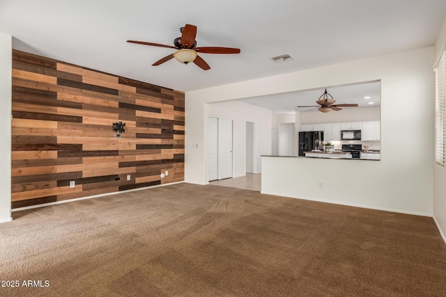 871 E Melanie St, San Tan Valley, AZ 85140 - unfurnished living room with ceiling fan, wood walls, and light carpet