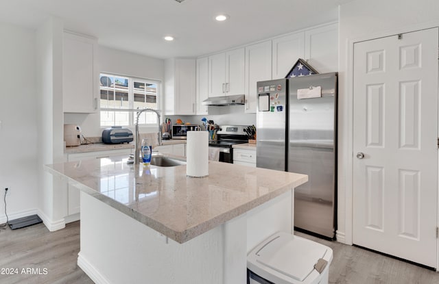 kitchen with light wood-type flooring, white cabinetry, a center island, and stainless steel appliances