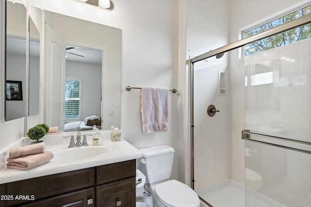 bathroom with toilet, vanity, and a shower with shower door