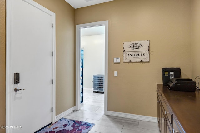 hall with beverage cooler and light tile patterned flooring