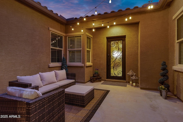 patio terrace at dusk featuring an outdoor hangout area