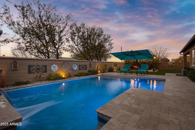 pool at dusk featuring a patio area