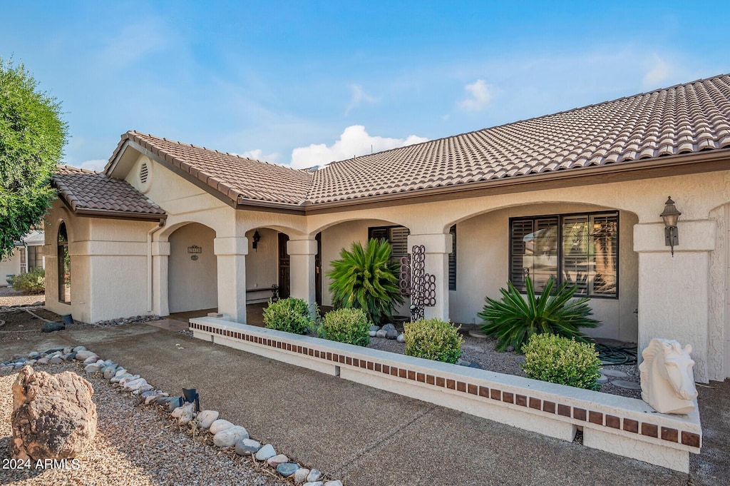 mediterranean / spanish-style home featuring a tile roof and stucco siding