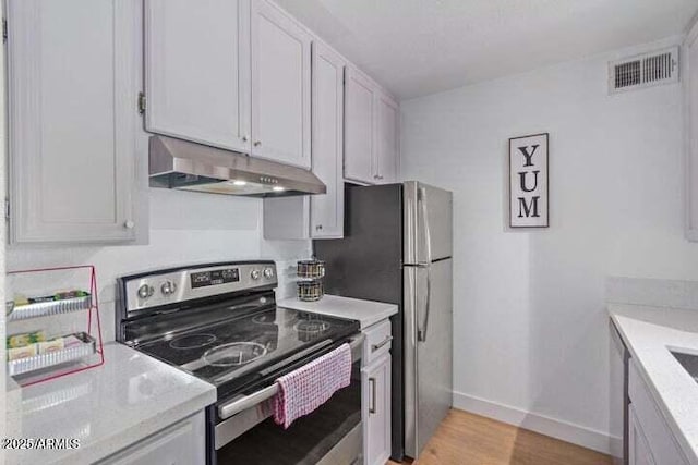 kitchen with electric range, visible vents, light wood-type flooring, baseboards, and under cabinet range hood