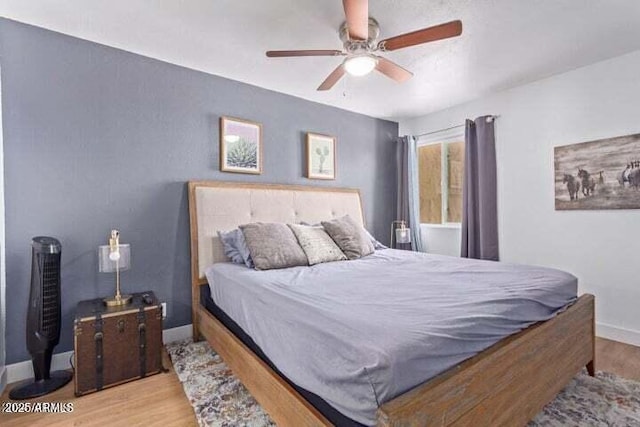 bedroom featuring baseboards, ceiling fan, and wood finished floors