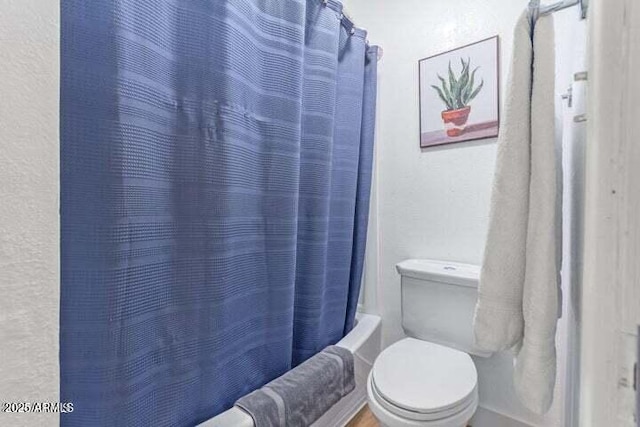 bathroom featuring toilet and shower / bathtub combination with curtain