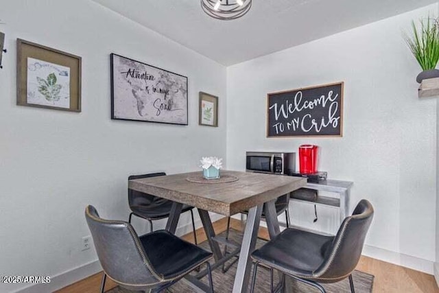dining area with baseboards and wood finished floors