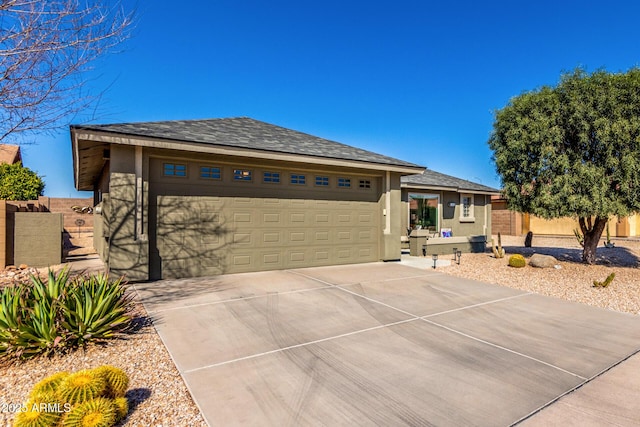 ranch-style home with a garage, fence, concrete driveway, and stucco siding