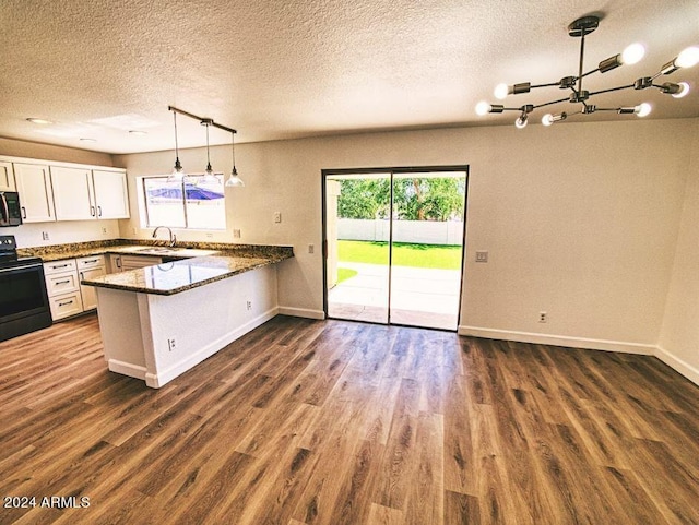 kitchen featuring kitchen peninsula, dark hardwood / wood-style flooring, white cabinetry, and black appliances